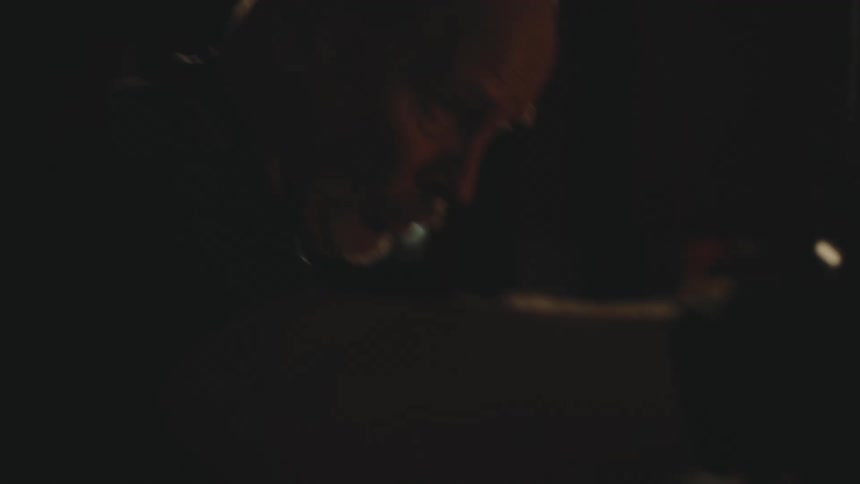 Close up of a middleaged boxer hitting a punching bag on a dimly lit room