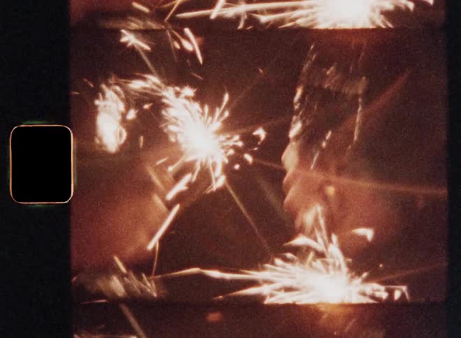 Group of two people holding sparklers and sparks flying around them while drinking champagne in the dark at night as they clink their glasses to toast and celebrate with a happy festive mood and positive vibe