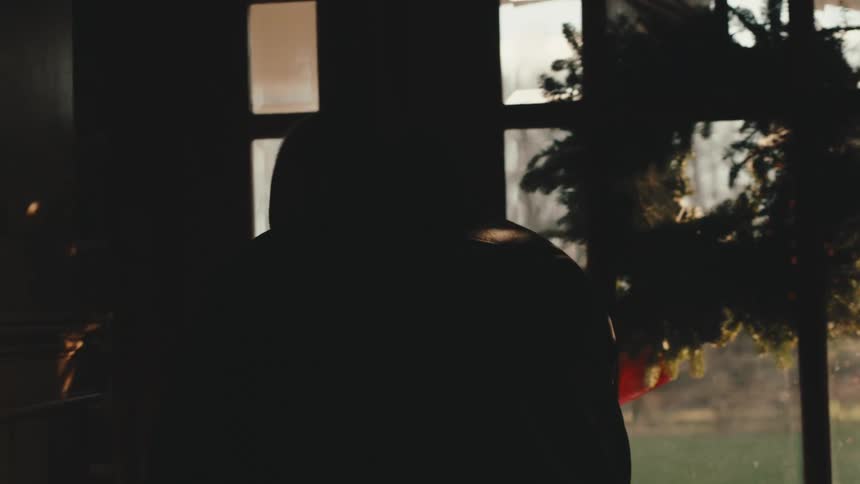 A man puts on a jacket before leaving home at morning
