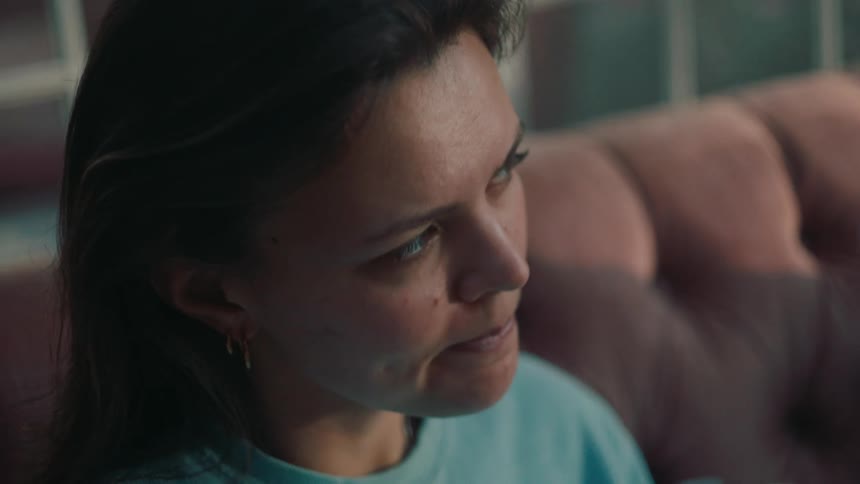 Close up of the face of a woman sitting on a couch at home