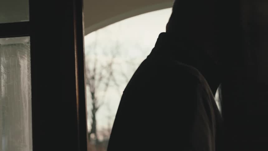 A person is in a dark place and goes out through the door to the outside