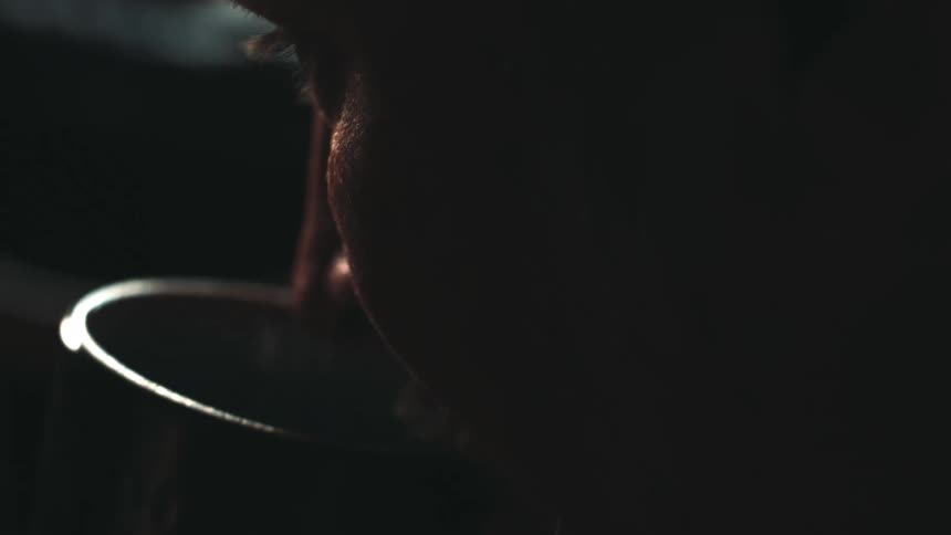A man takes a sip from a black cup