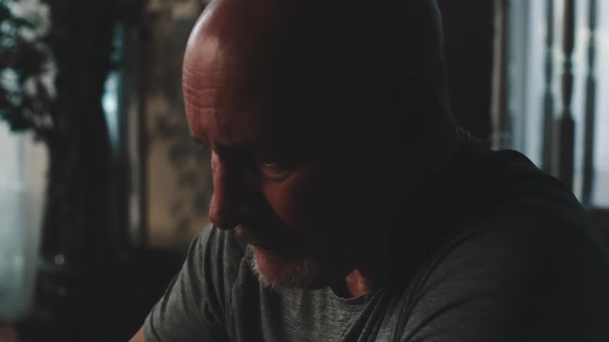Man sitting at a table drinking a cup of coffee
