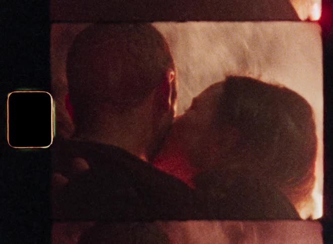 Silhouette of a woman kissing her boyfriend on the cheek while fireworks appear at night in the background while they celebrate the beginning of a new love or romance on New Year’s Eve