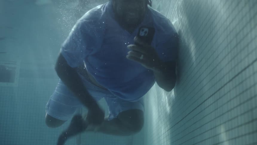 Man in the pool retrieving his phone