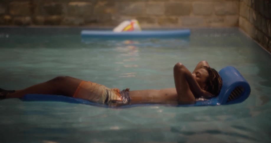 A man relaxing as he floats in the pool