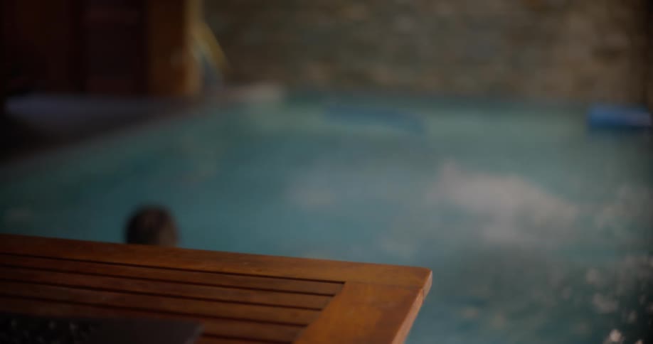 A mischievous boy grabs his dads smartphone and throws it in the pool