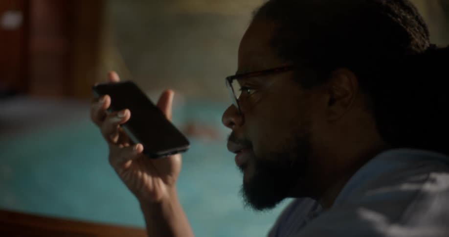 A man is talking on his phone by the pool