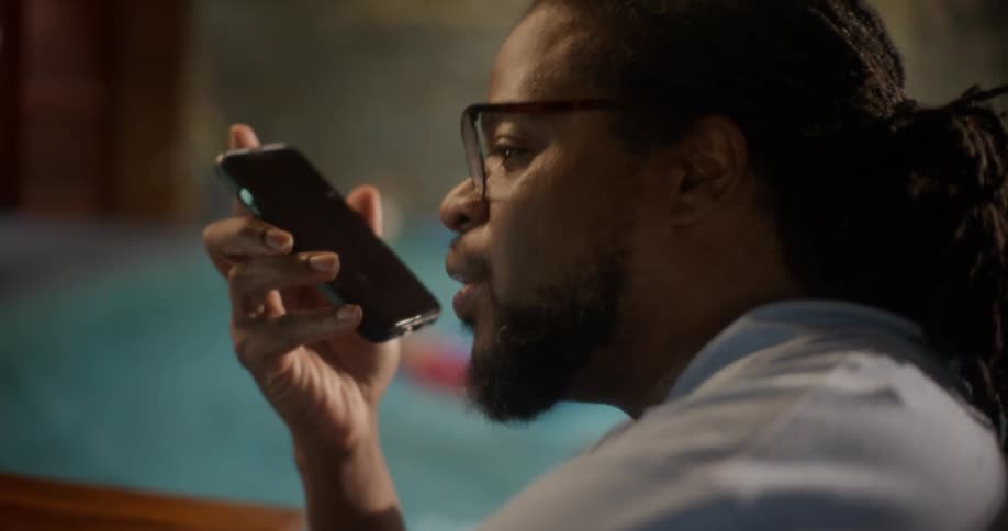 A man talks on his cell phone by the pool
