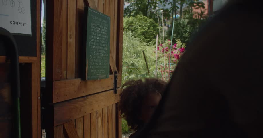 Woman entering a gardening tool shed with a small little boy