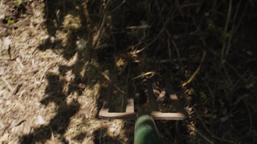 A person is shoveling hay with a pitchfork