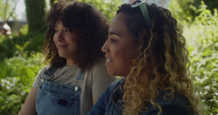 Portrait of two smiling women sitting in a garden
