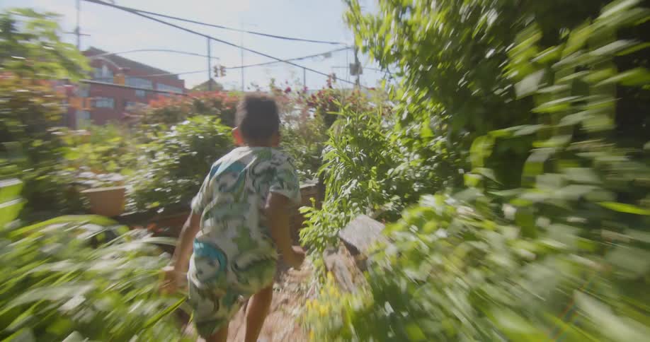 Two boys running around playing and having fun in a city garden