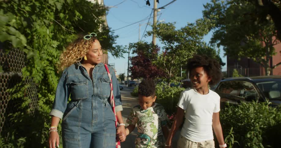 Mother walking on the sidewalk with two small children