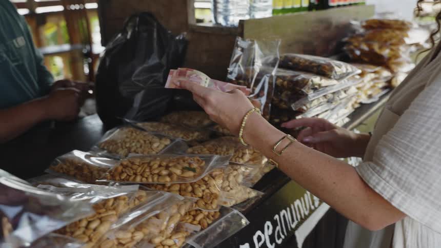 Woman handing a money note to a man in a store