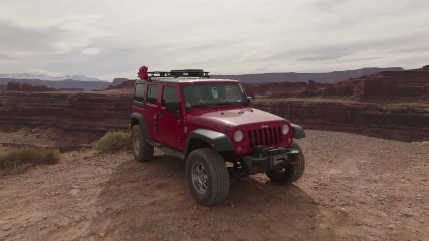 A jeep is parked by the cliff