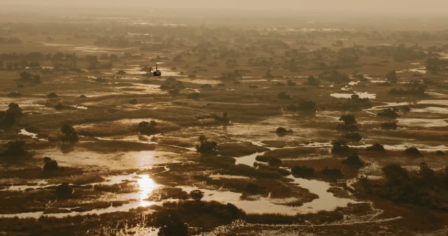 A helicopter flying over a swamp with some rivers