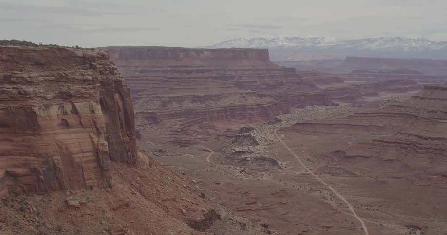 A large canyon with a road near mountains