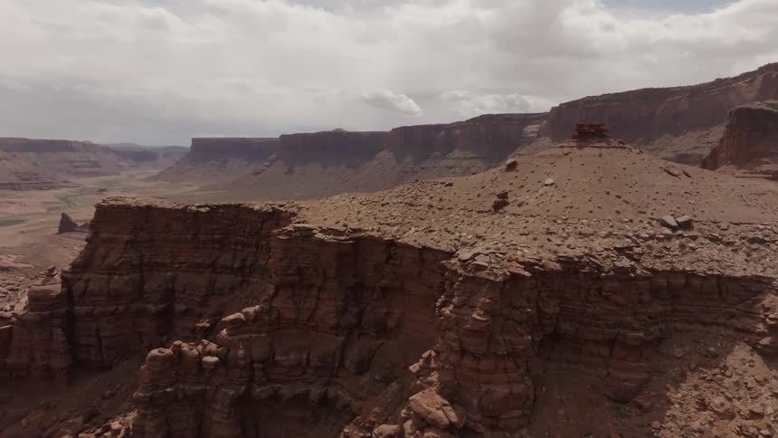 Tall cliffs tower over canyon floor under an overcast sky
