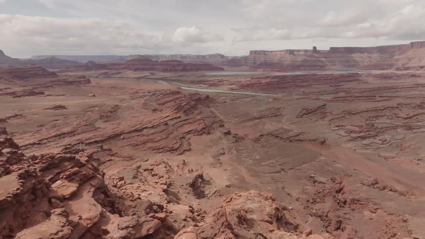 A desert with some mountains of rocks and reddish sand