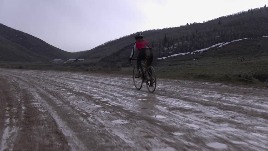 Person riding a bike over a muddy path