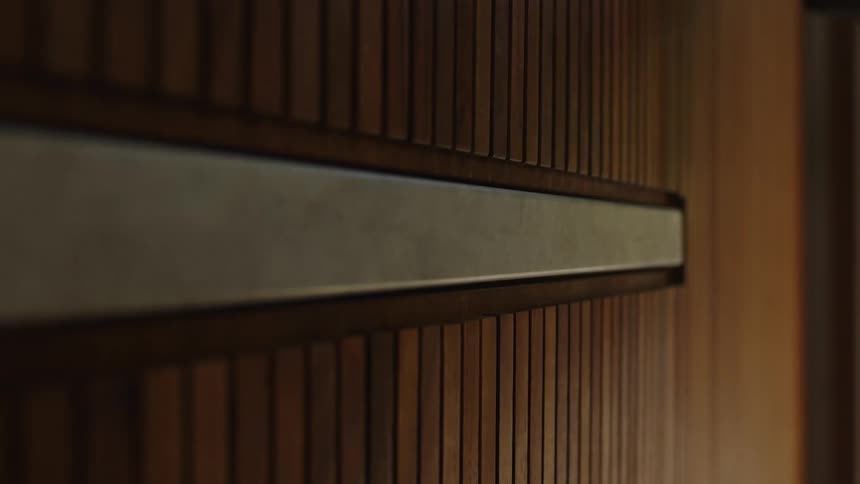 A closeup of a wooden door partially open with a persons hand on the edge