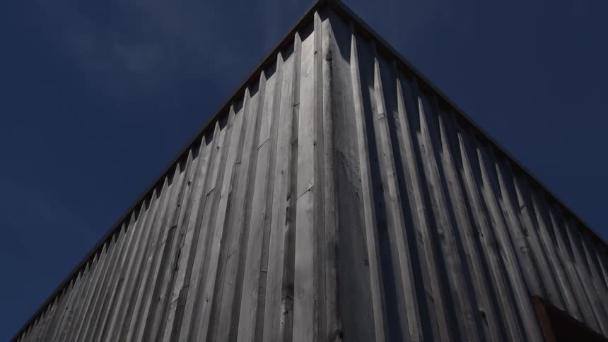 Exterior architecture of the outside of a house wall that is reflected against a blue sky