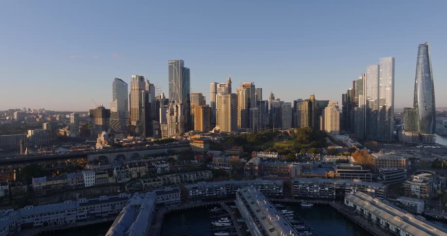 The center of a metropolitan city has very tall buildings and in front there is a marina with boats parked