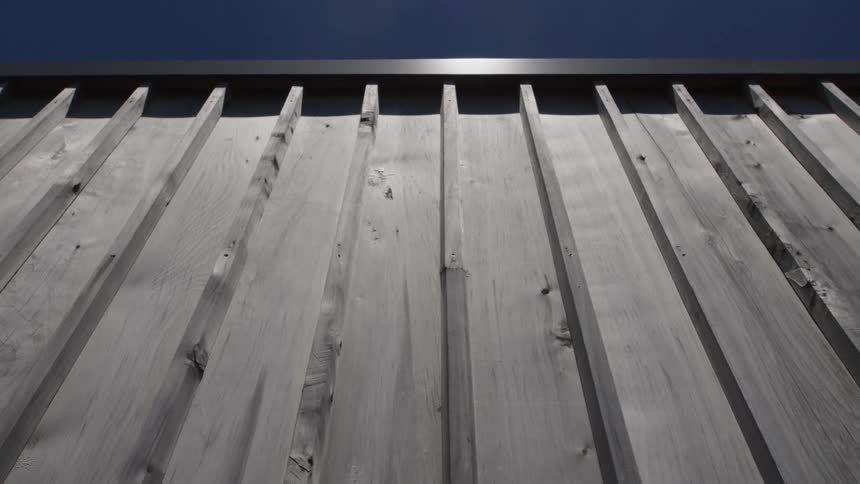 Close up of a wooden wall under a bright blue sky