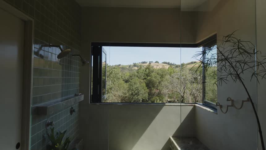 Aerial view of a field with trees around it and the interior of the bathroom of a modern house