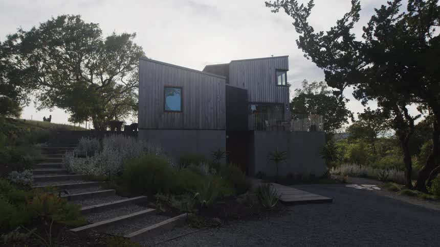 Outdoor steps curve around rural house with a modern architectural design