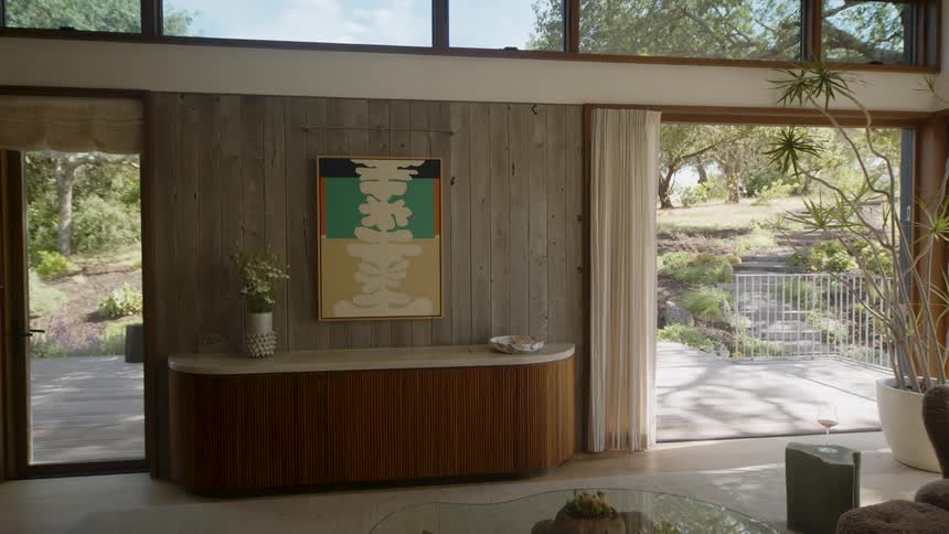A young woman opens a retracting door in her stylish home