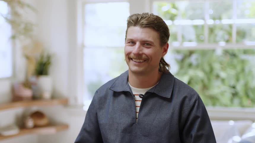 Portrait of a smiling man indoors and pointing fingers forward