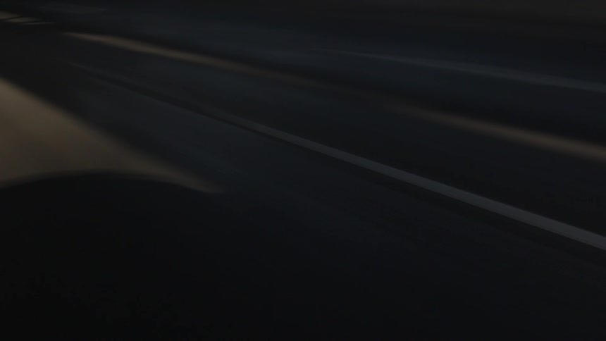 A view from inside a car of an asphalt street speeding by