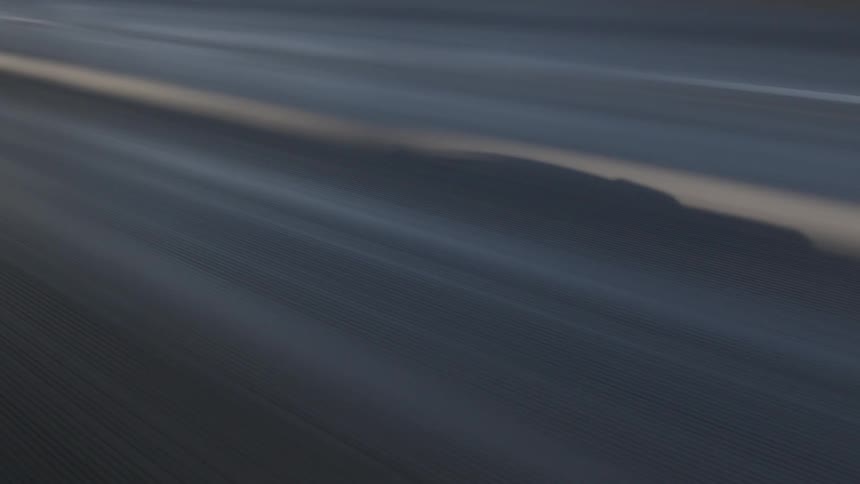 Blurred lines of a highway across a bridge fly by