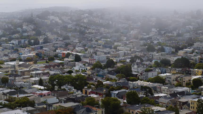 Aerial view of a densely packed neighborhood under thin clouds
