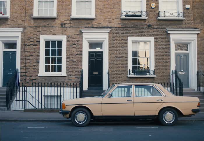 Classic car parked next to a residential building
