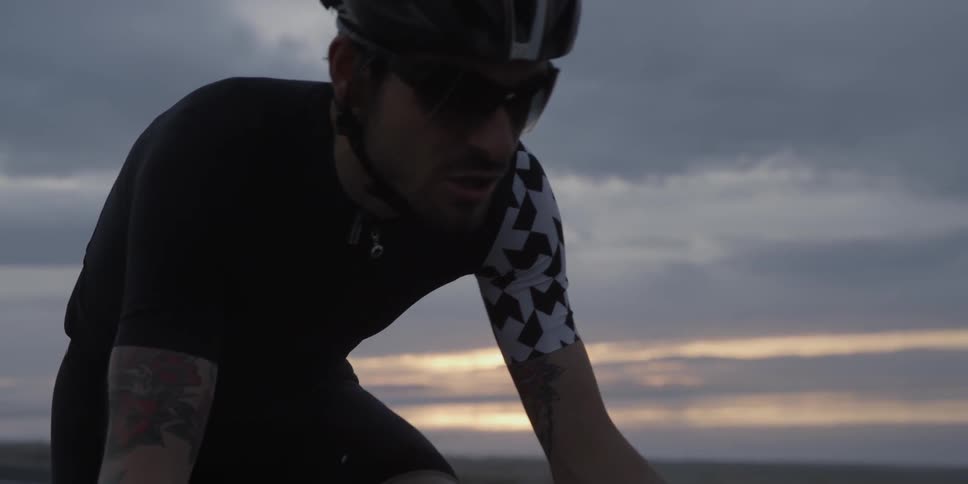 A cyclist is riding a bicycle on a cloudy day