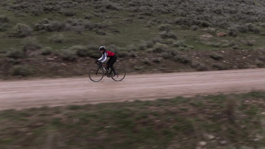 Person riding bicycle on dirt road