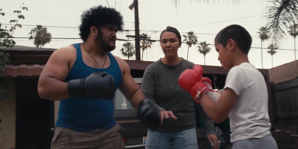 Man and a boy preparing to box when a woman interrupts