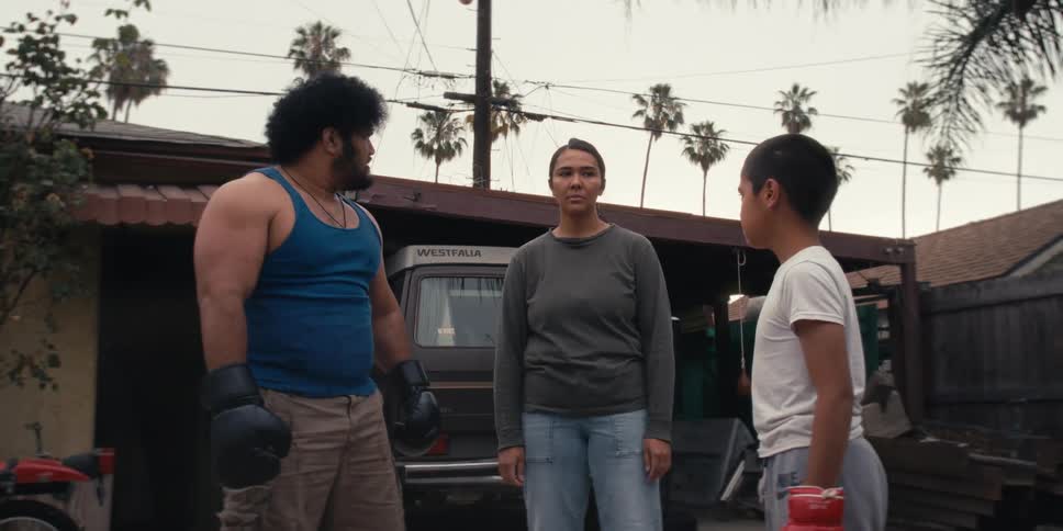 Father and son with boxing gloves while the father argues aggressively with the mother
