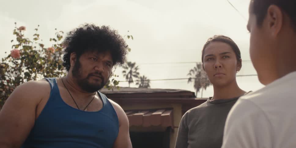 Boy talking to a man who is wearing a boxing glove next to a woman