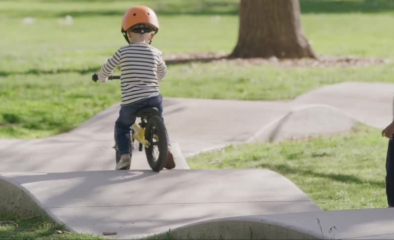 A child follows another child on a bicycle