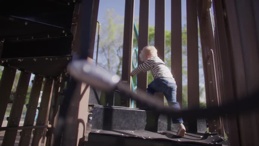Little blond boy climbing the stairs on a toy