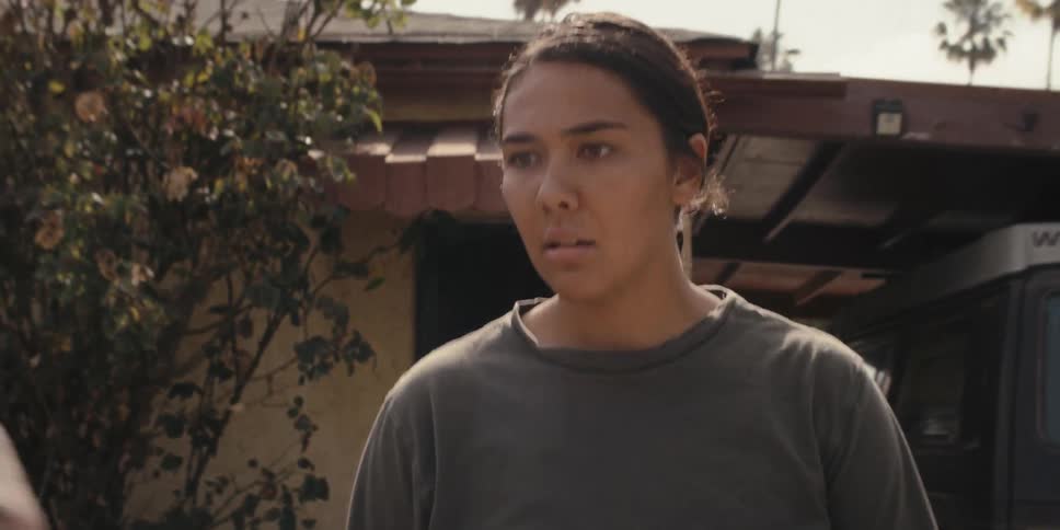 A woman comes out of the house upset at a man boxing in the backyard