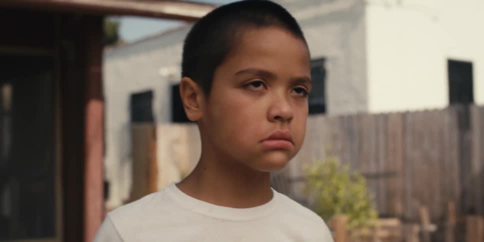 Portrait of a boy wiping his crying face with a boxing glove