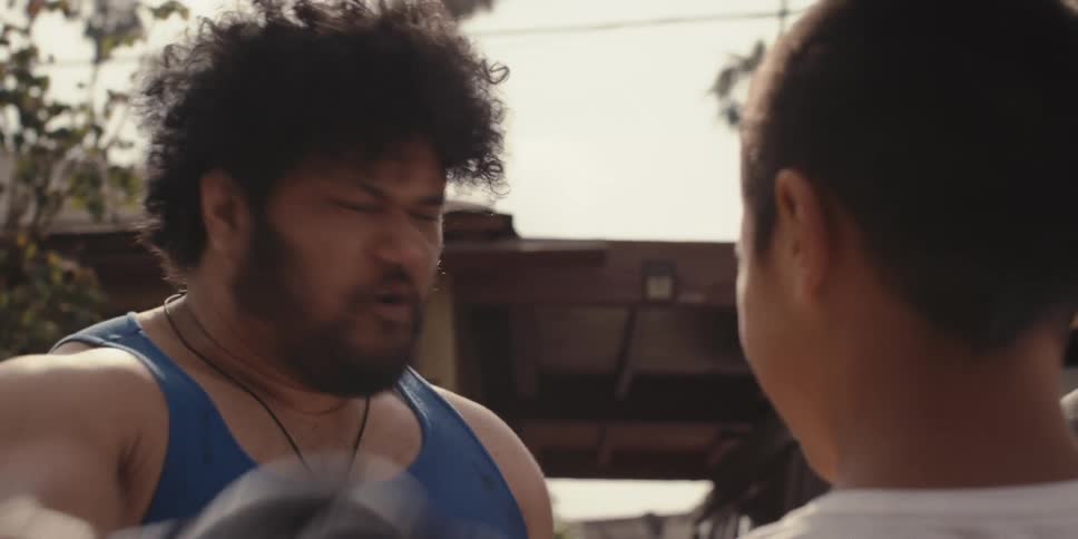 A man wearing boxing gloves shouts at a child and another person off camera
