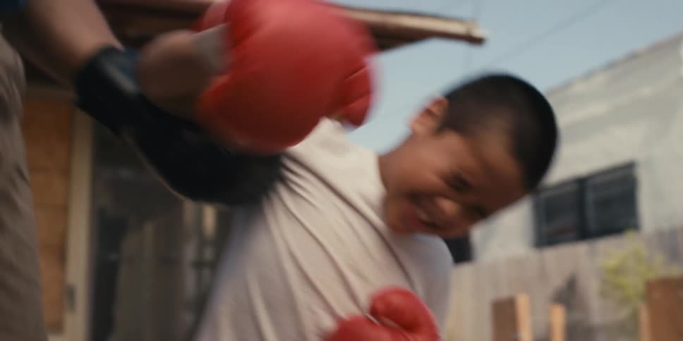 A man lifts a boy to his feet during a boxing match