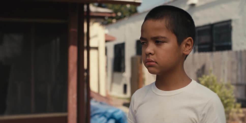 A child is standing in his yard