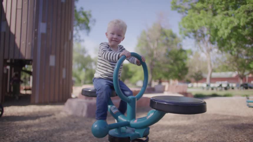 Smiling little boy playing a toy in a park